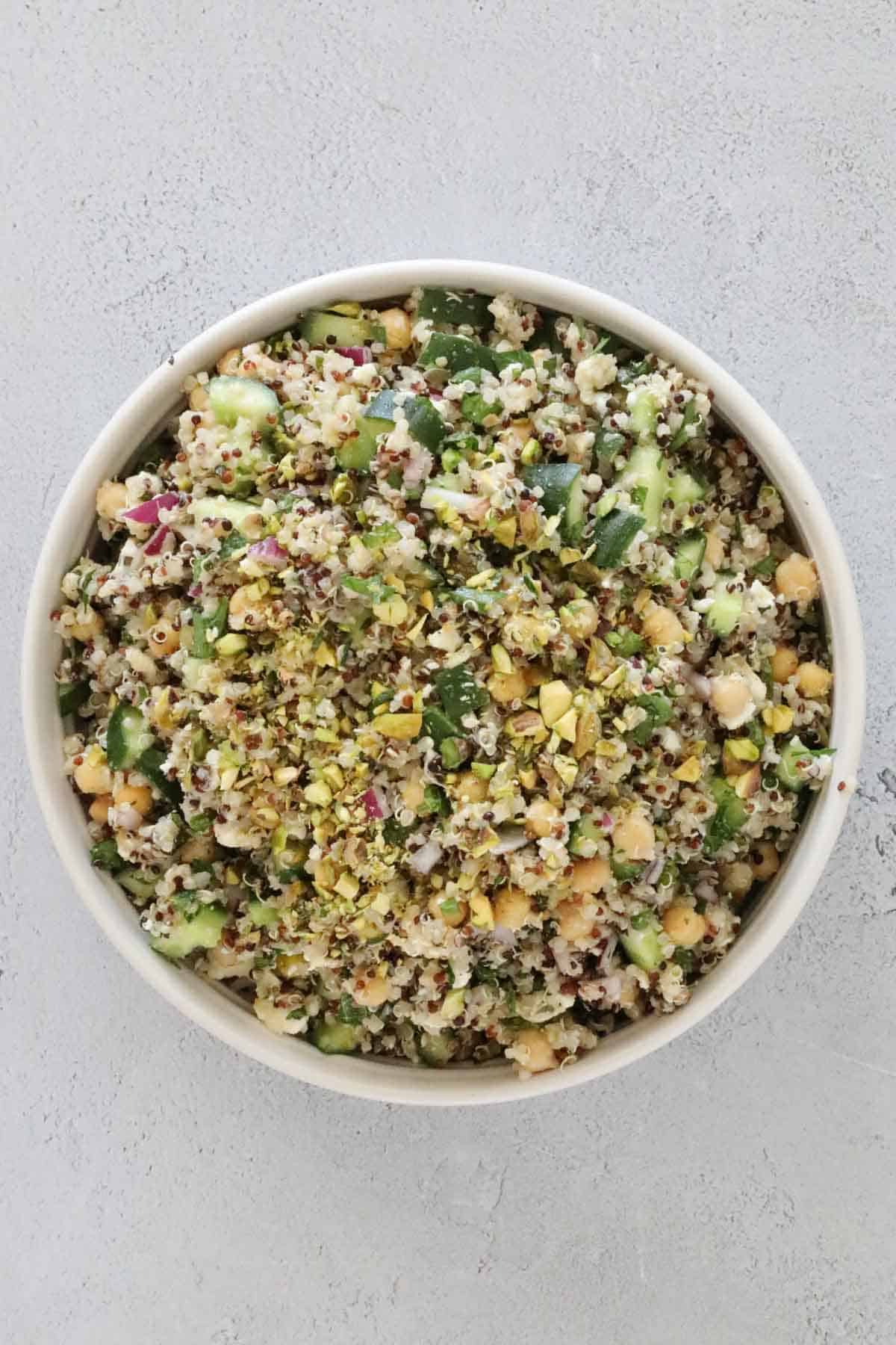 A bowl of Jennifer Aniston salad with chickpeas, quinoa, cucumber and pistachios.