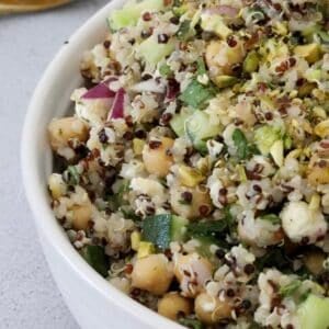 A bowl of chickpeas, quinoa, cucumber and red onion.