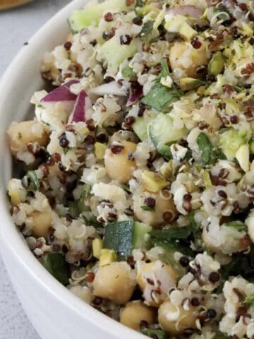 A bowl of chickpeas, quinoa, cucumber and red onion.