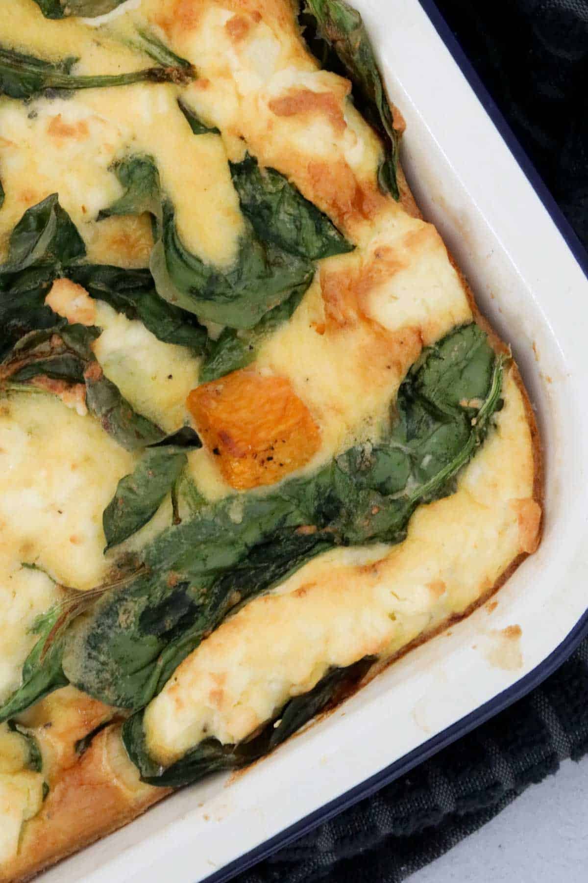 Baked frittata in a white enamel dish.