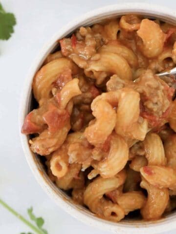 An overhead shot of a bowl of cheesy taco pasta.