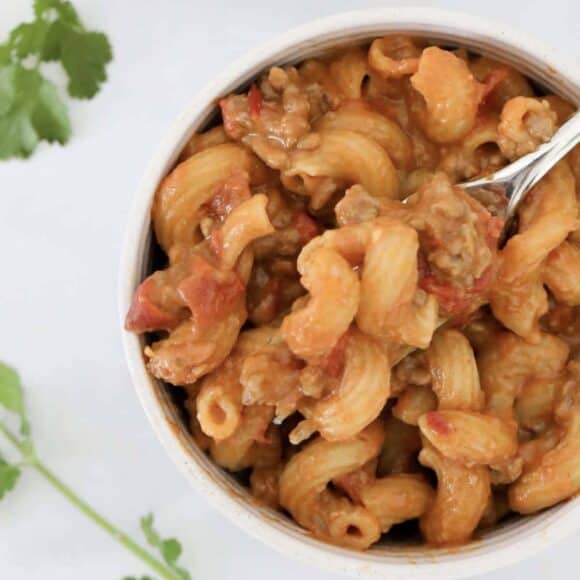 An overhead shot of a bowl of cheesy taco pasta.