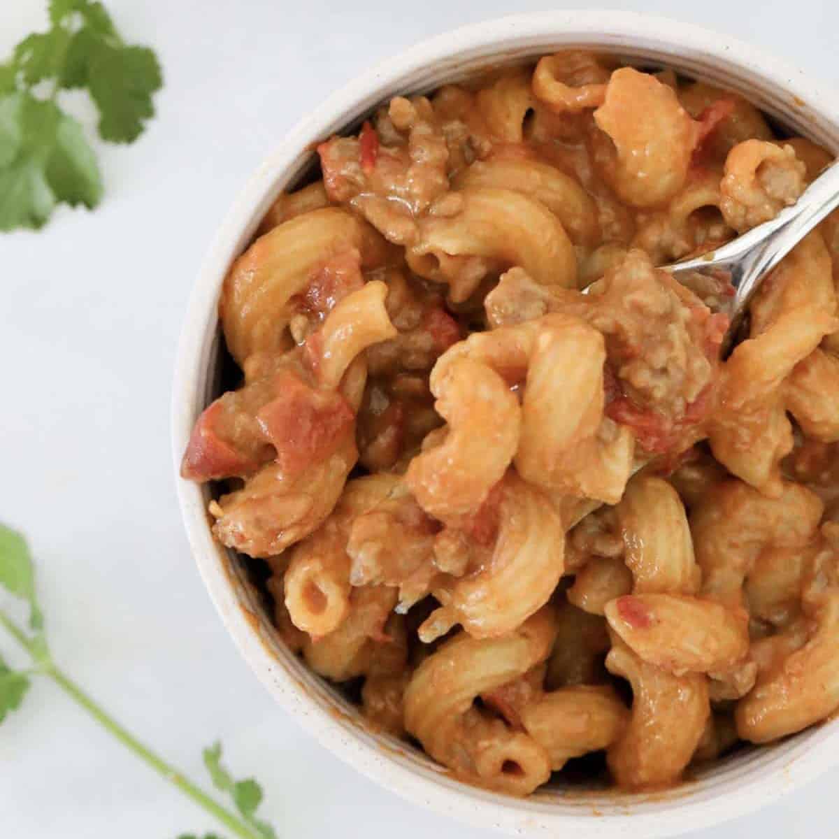 An overhead shot of a bowl of cheesy taco pasta.