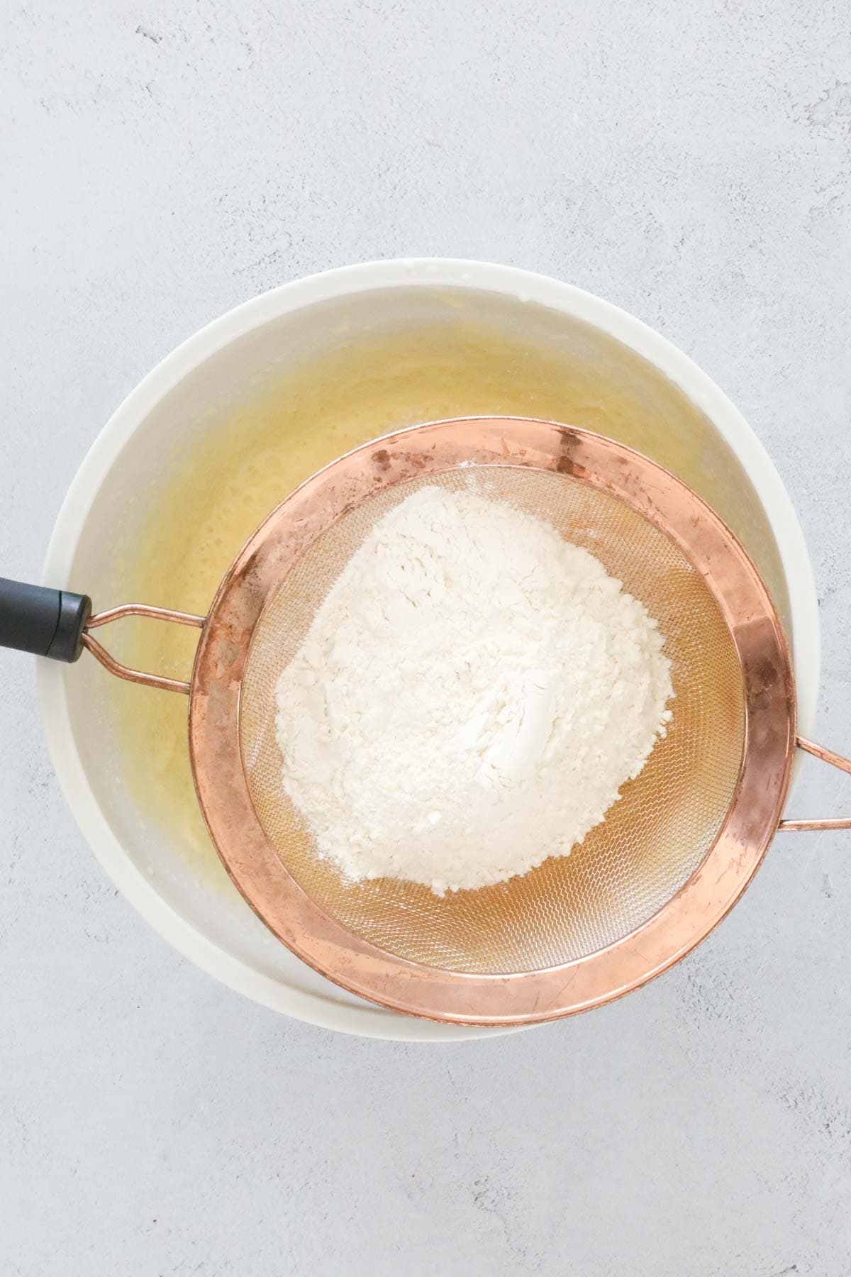 Flour being sifted into a bowl.