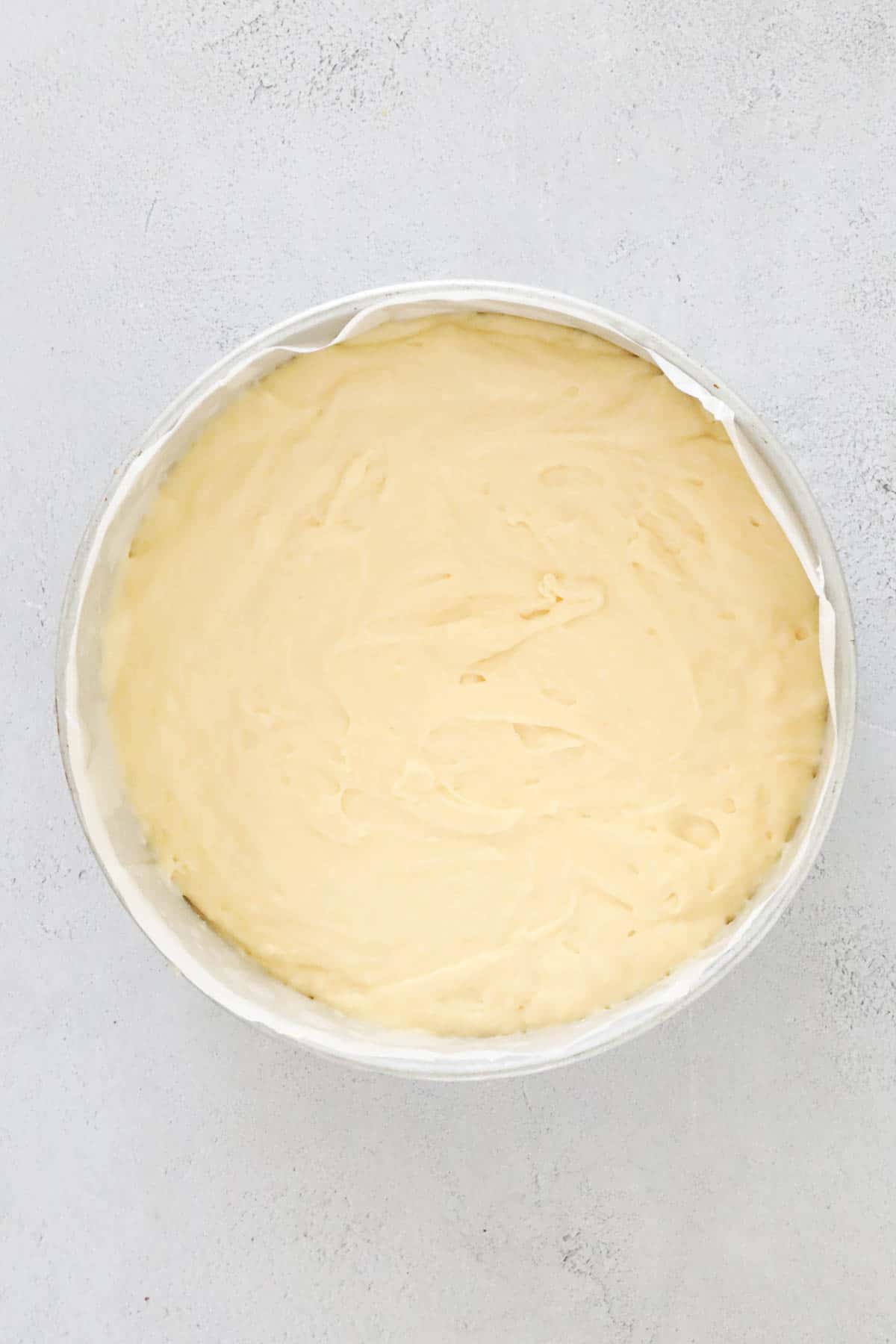 Cake batter in a round tin.
