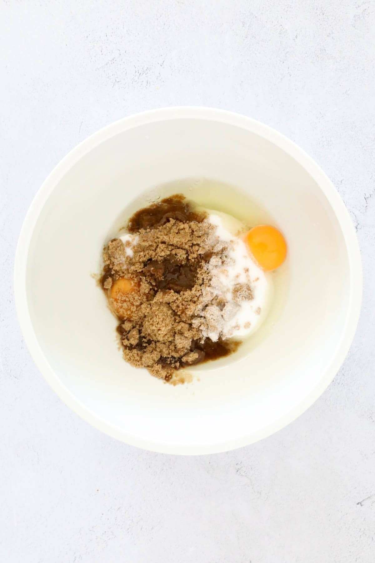 Eggs, caster sugar and brown sugar in a bowl.
