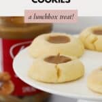 Thumbprint cookies on a cake stand, in front of a jar of Biscoff spread.
