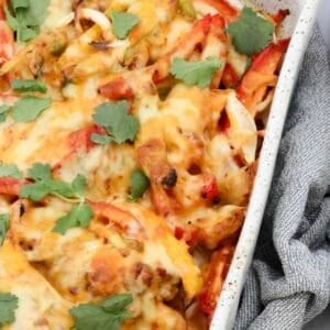 Freshly baked chicken fajita casserole topped with golden melted cheese and garnished with fresh coriander.