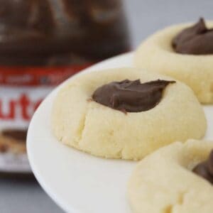 Butter cookies filled with Nutella on a cake stand.