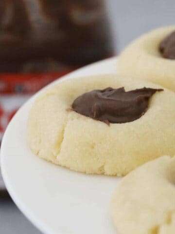 Butter cookies filled with Nutella on a cake stand.