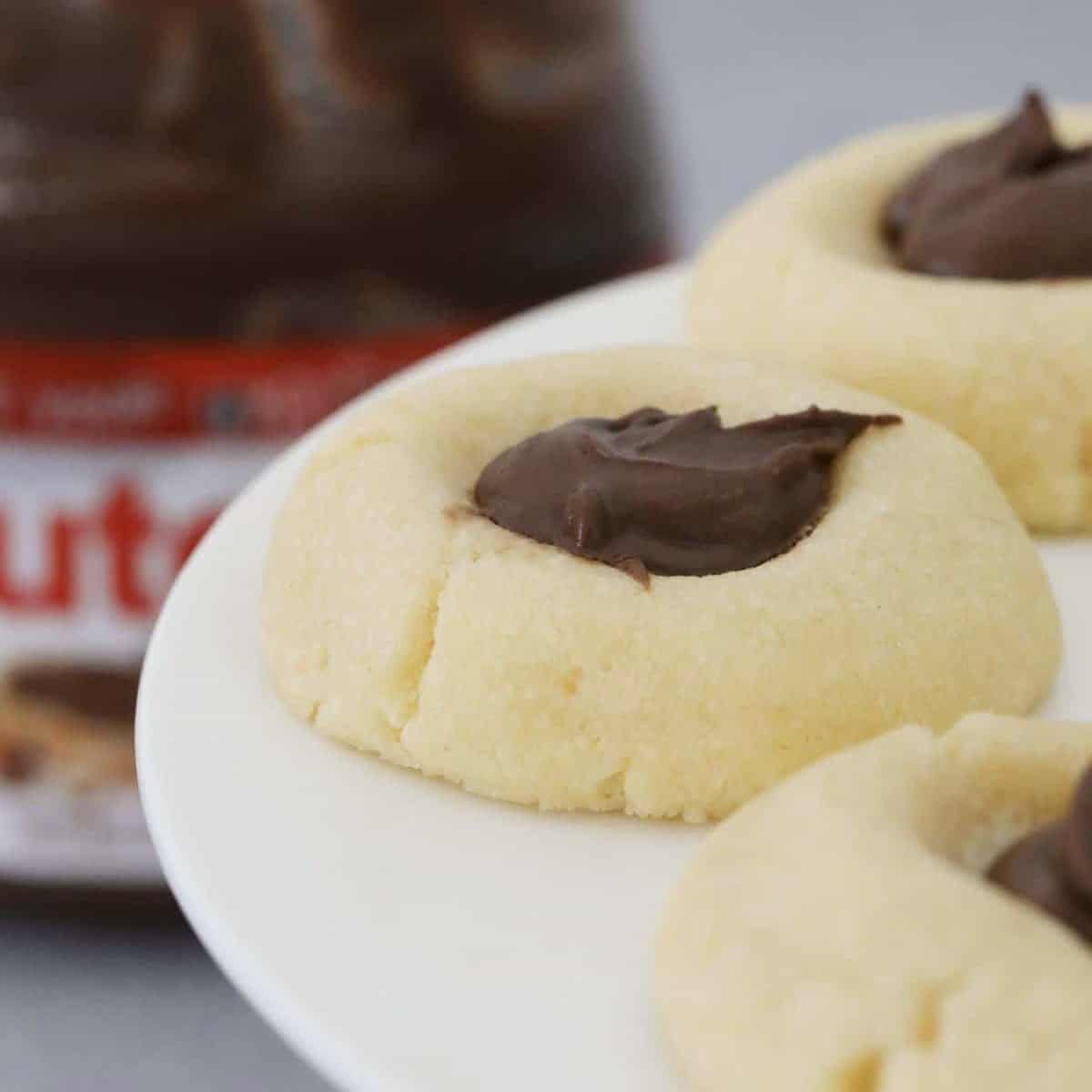 Butter cookies filled with Nutella on a cake stand.