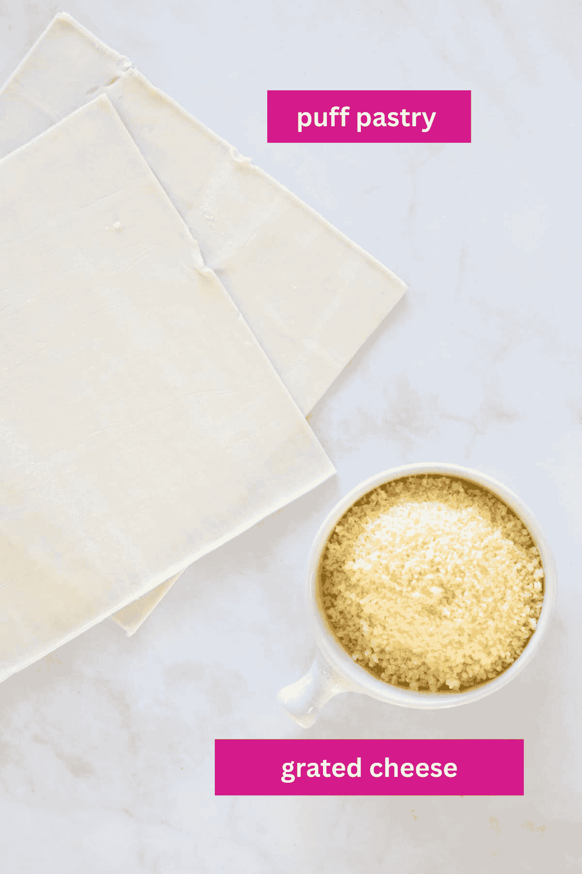An overhead shot of puff pastry and grated cheese.