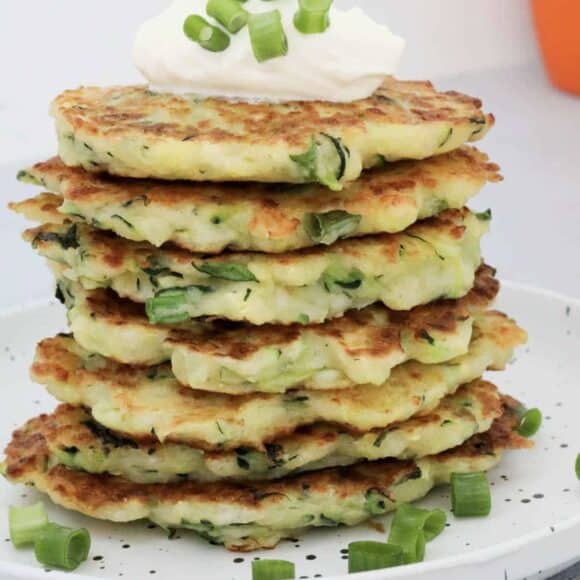 A stack of halloumi and zucchini fritters on a plate.