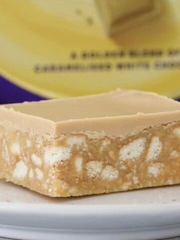 A piece of no bake caramel hedgehog slice in front of a block of caramel chocolate.