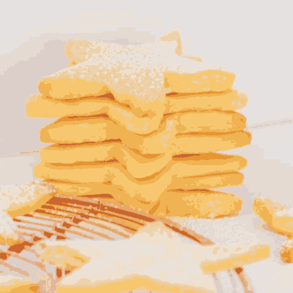A stack of shortbread stars with icing sugar sprinkled on top.